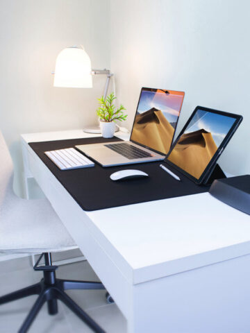 a laptop and a tablet sitting on a desk.