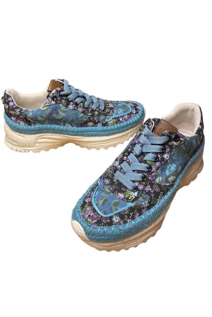 a pair of Coach tennis shoes with blue and purple floral pattern.