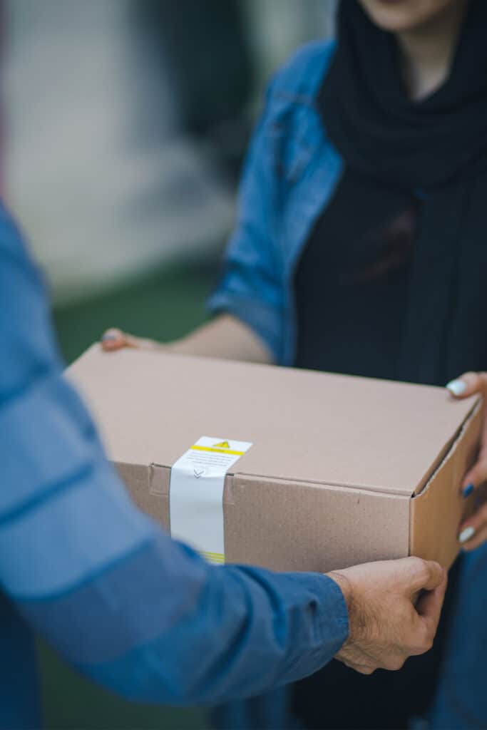 a man handing a woman a brown cardboard box.