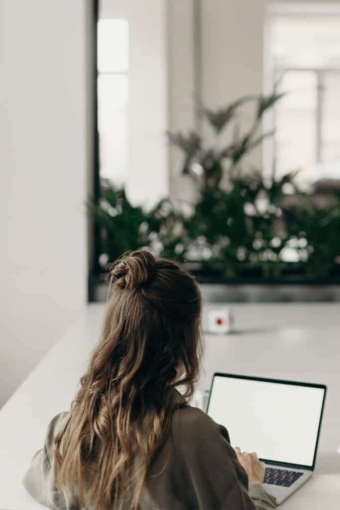 woman sitting at a table using a laptop.