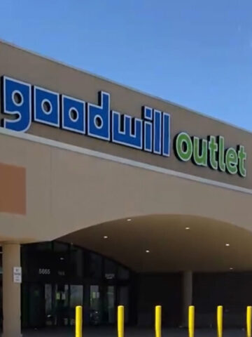 the storefront of a large building with the words goodwill outlet on the front.