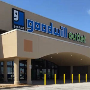 the storefront of a large building with the words goodwill outlet on the front.