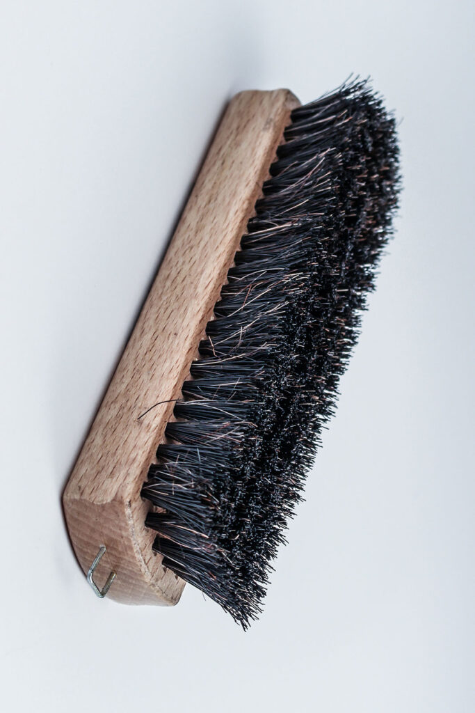 a black brush on a brown wood base.