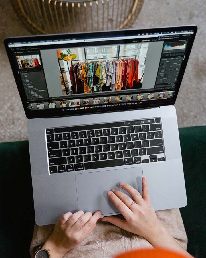 a person on a laptop editing a picture of clothes on photoshop.