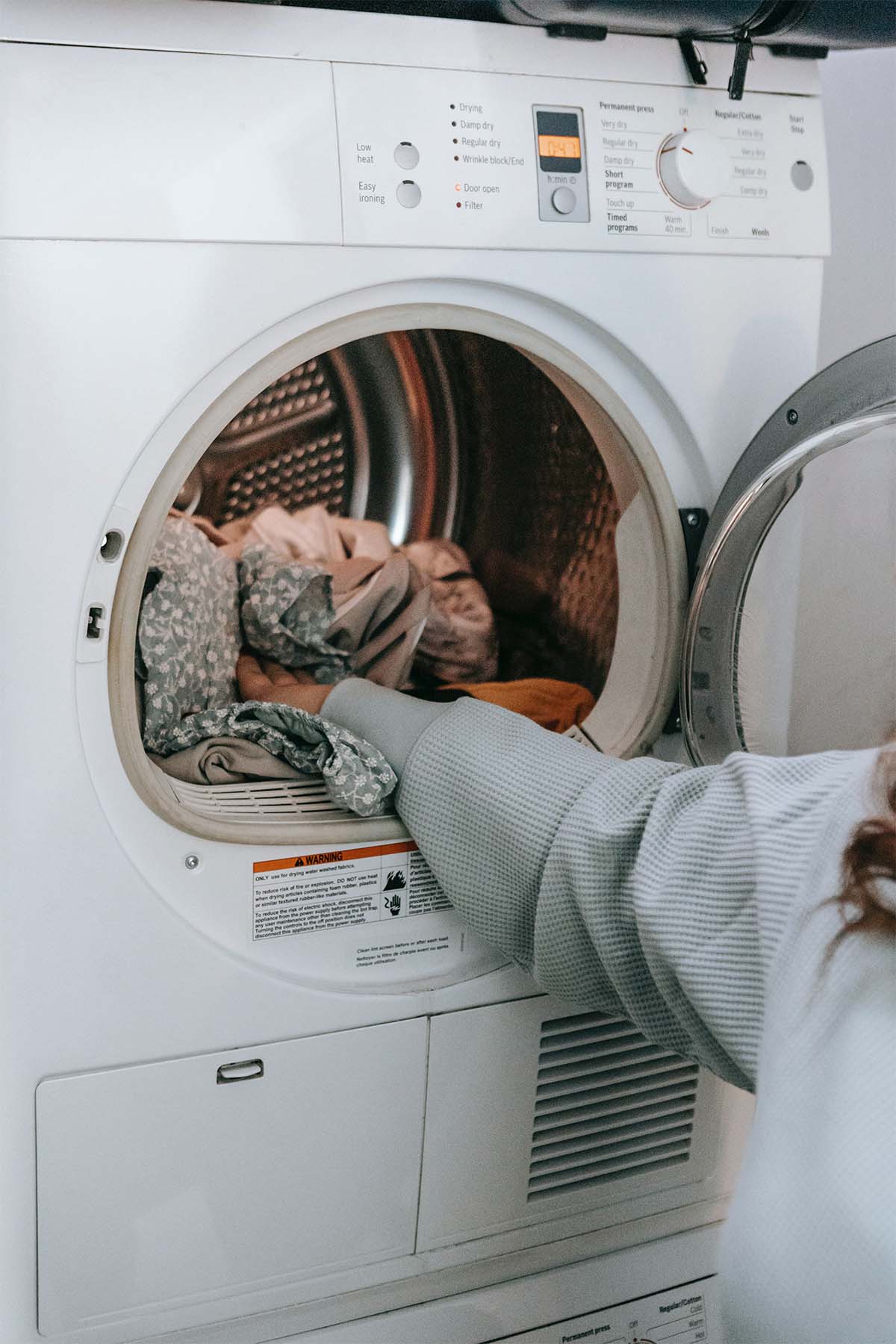 woman placing items in a washing machine.