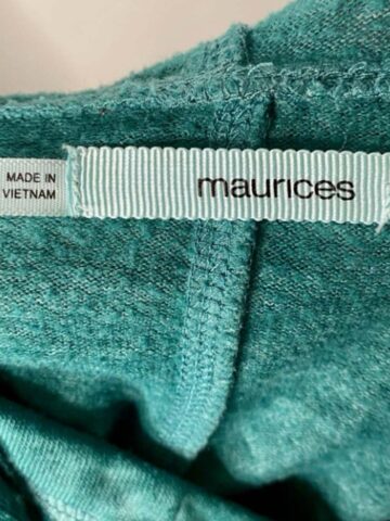 up close picture of a maurices brand and size tag on a green jacket.